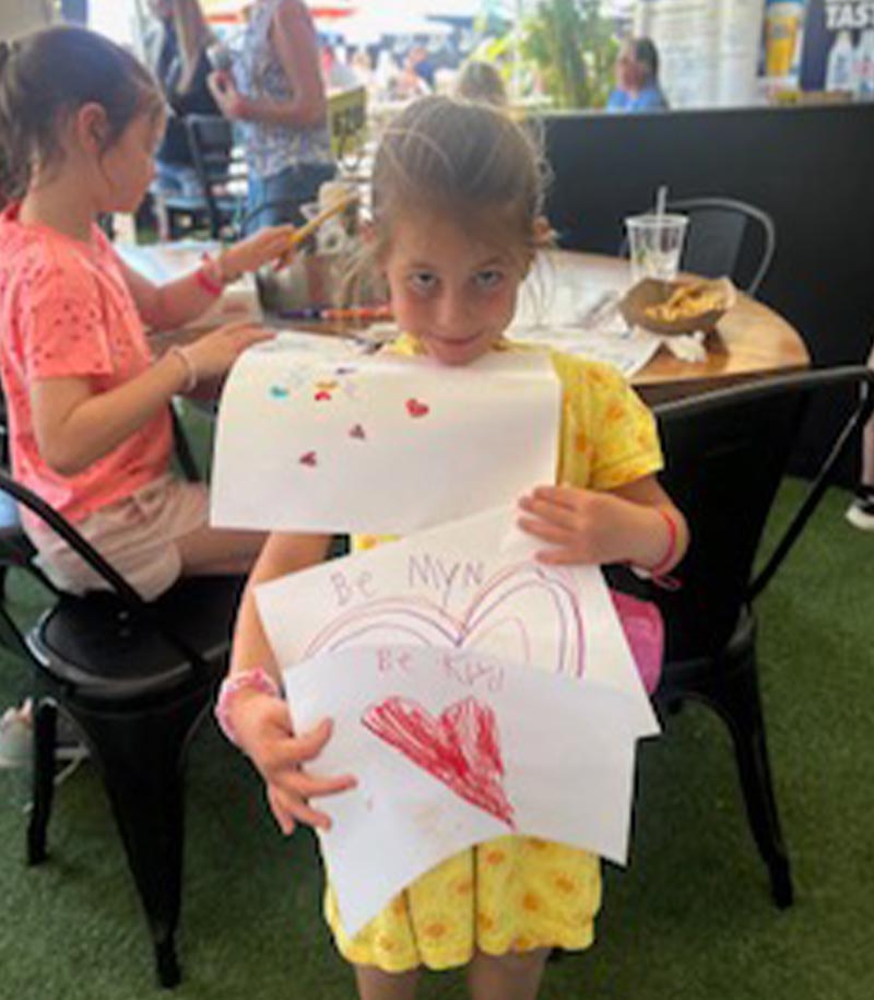 happy girl holding finished drawings for sketch for fetch event