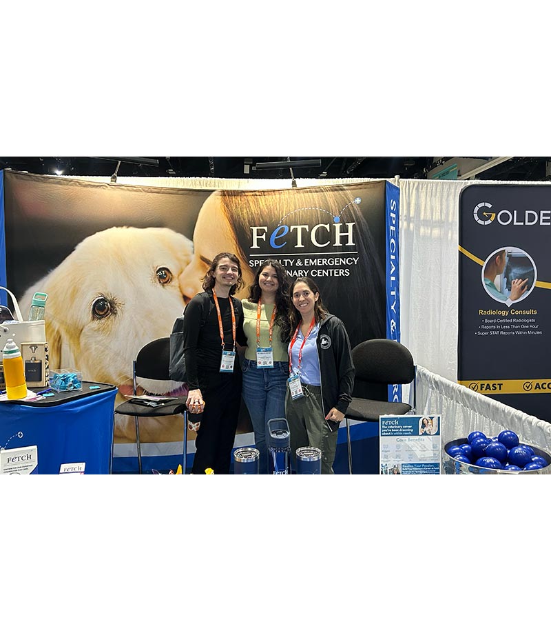 three staff members smiling and posing at Fetch Vets booth during IVECCS 2025