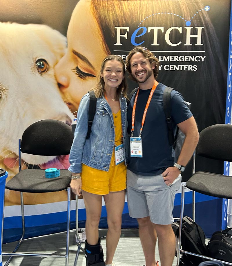 male and female smiling and posing in front of Fetch Vets booth at IVECCS 2025