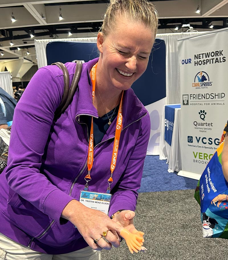 female staff member laughing while clapping with tiny hand finger puppets