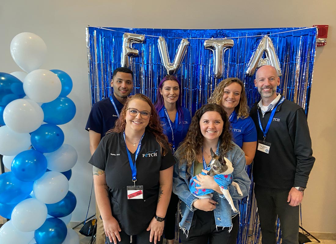 staff members smiling and posing in front of FVTA photobooth setup with balloons